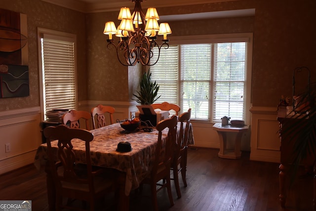 dining room with dark hardwood / wood-style flooring, ornamental molding, and an inviting chandelier