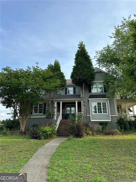 view of front of house featuring covered porch and a front yard