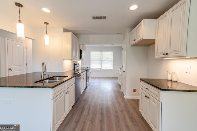 kitchen featuring hanging light fixtures, white cabinetry, and sink