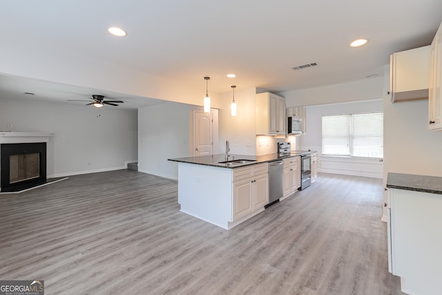 kitchen featuring pendant lighting, appliances with stainless steel finishes, sink, and white cabinets