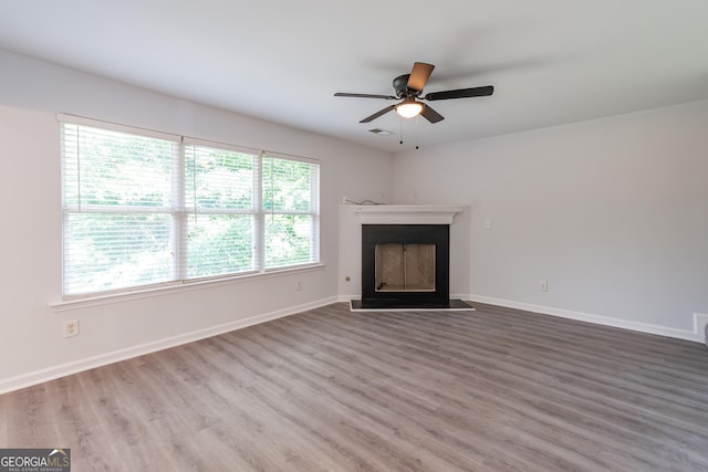 unfurnished living room with hardwood / wood-style flooring and ceiling fan