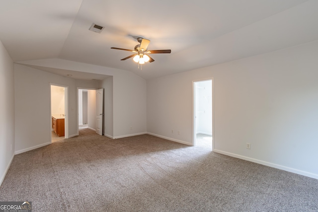 empty room featuring vaulted ceiling, light colored carpet, and ceiling fan