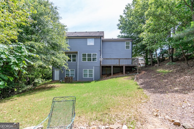 rear view of house featuring a deck and a lawn