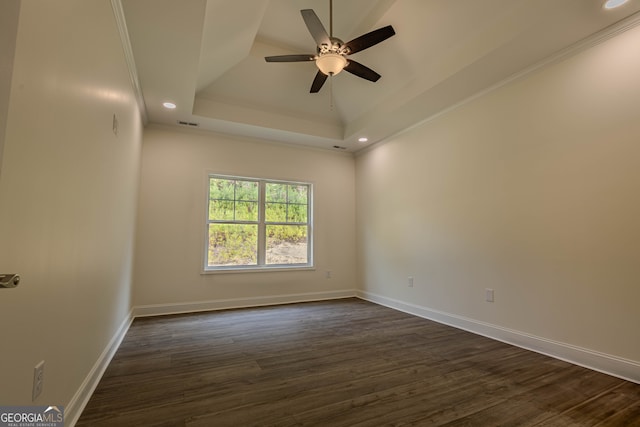 spare room featuring crown molding, dark hardwood / wood-style floors, a raised ceiling, and ceiling fan