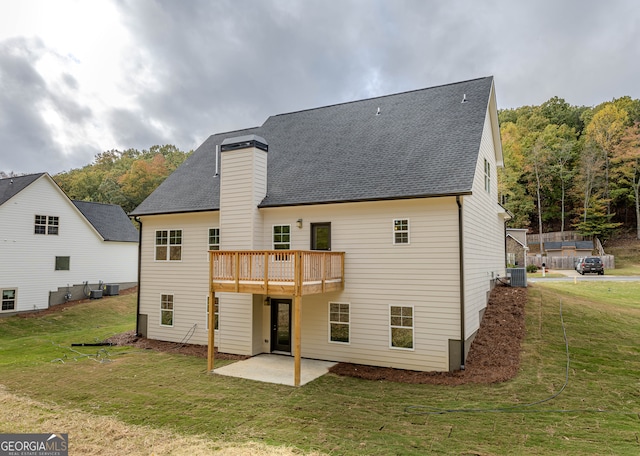 back of property with central AC, a yard, and a patio area