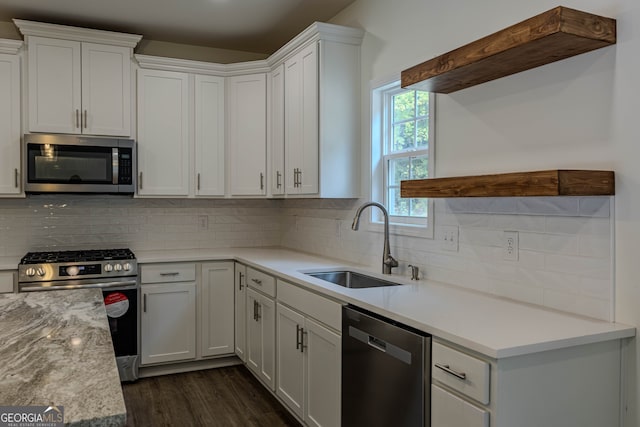 kitchen with decorative backsplash, dark wood-type flooring, sink, white cabinetry, and appliances with stainless steel finishes