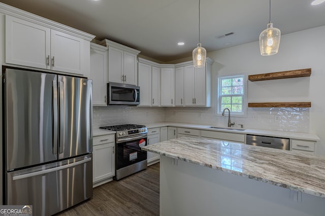 kitchen featuring appliances with stainless steel finishes, sink, backsplash, white cabinets, and light stone counters