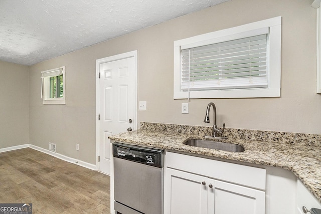 kitchen featuring appliances with stainless steel finishes, white cabinets, wood-type flooring, and light stone counters