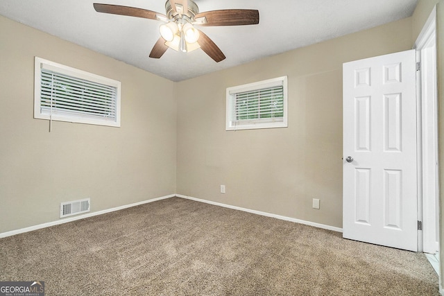 carpeted spare room with ceiling fan