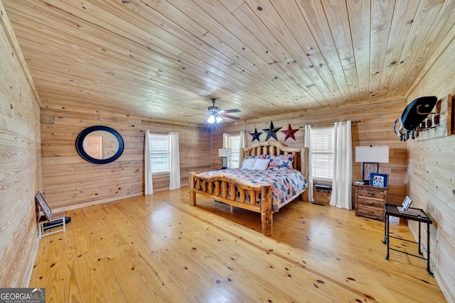 bedroom with wooden walls, hardwood / wood-style floors, ceiling fan, and wood ceiling