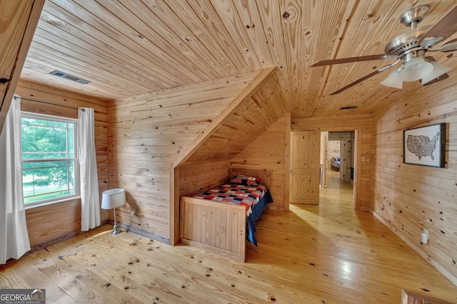 unfurnished bedroom featuring ceiling fan, wood walls, light wood-type flooring, and wood ceiling