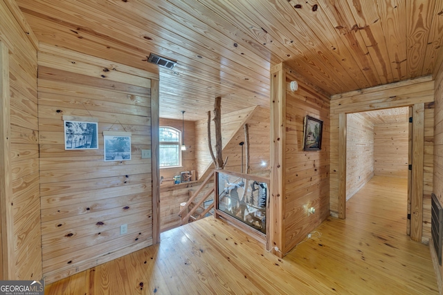 bonus room with wood-type flooring, wood walls, and wood ceiling