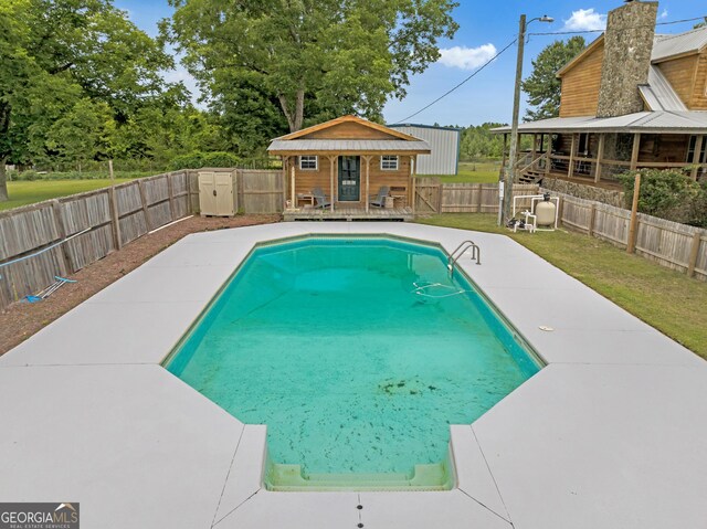 view of pool with an outdoor structure and a yard