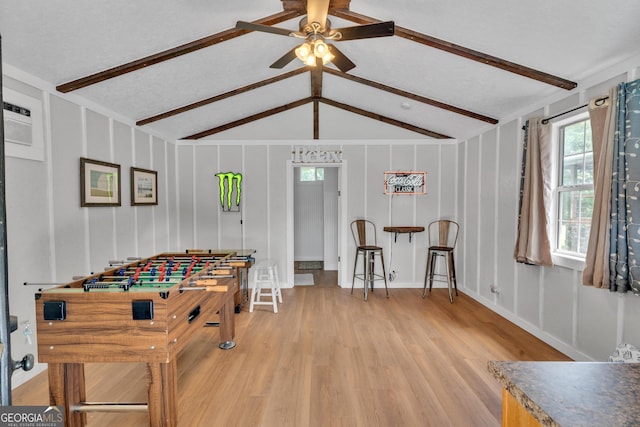 recreation room with vaulted ceiling with beams, ceiling fan, and wood-type flooring