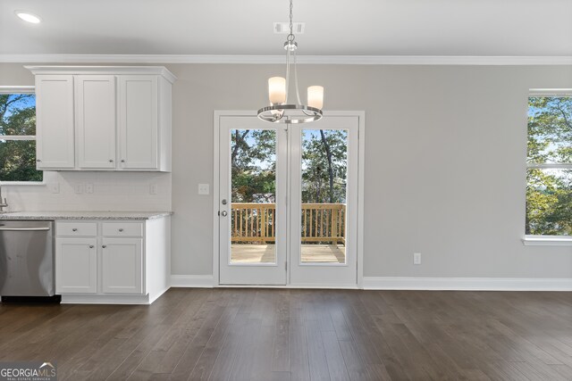 unfurnished dining area featuring a notable chandelier, ornamental molding, dark hardwood / wood-style floors, and a wealth of natural light