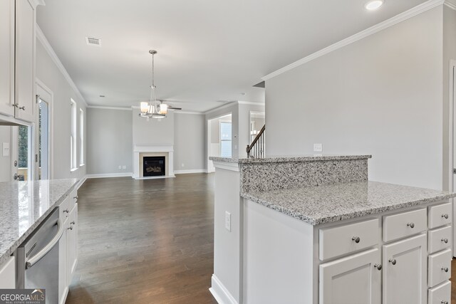 kitchen with white cabinets, stainless steel dishwasher, decorative light fixtures, and dark hardwood / wood-style flooring