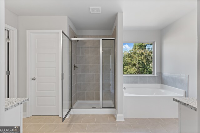 bathroom featuring independent shower and bath, vanity, and tile patterned floors