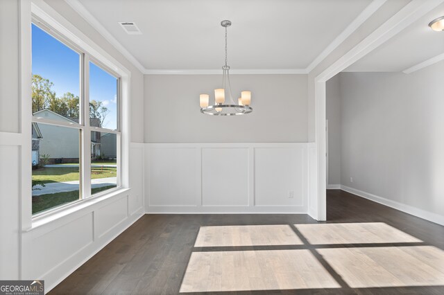 unfurnished dining area featuring ornamental molding, a wealth of natural light, a chandelier, and dark hardwood / wood-style floors