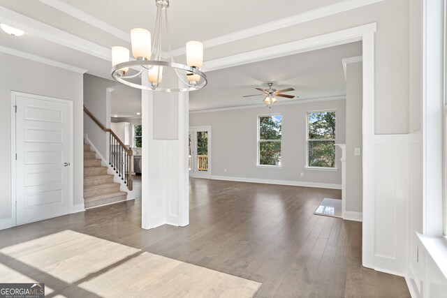 interior space with ceiling fan with notable chandelier, ornamental molding, and dark hardwood / wood-style flooring