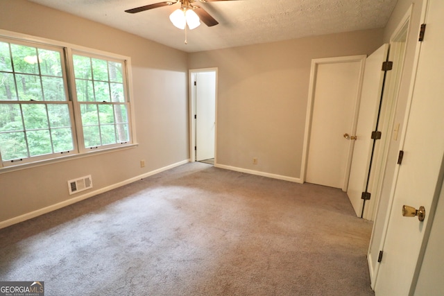 interior space with a textured ceiling and ceiling fan