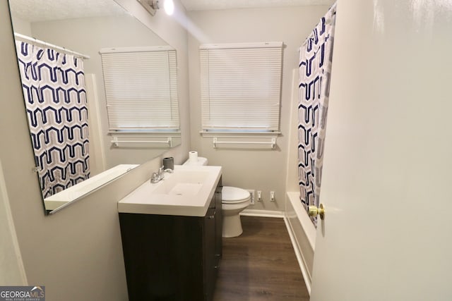 full bathroom featuring hardwood / wood-style floors, vanity, toilet, and shower / tub combo with curtain