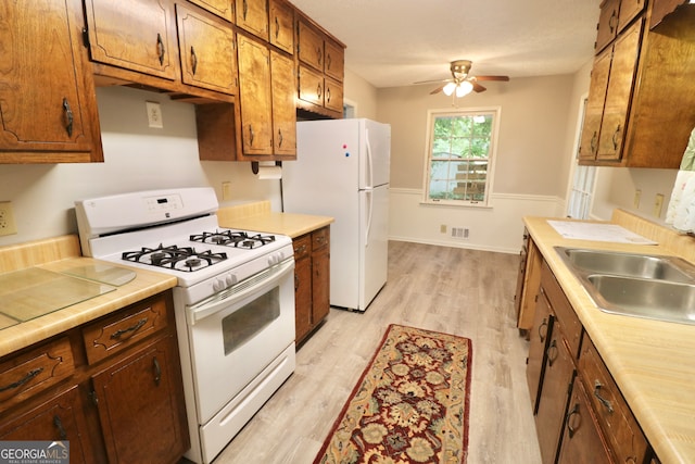 kitchen featuring ceiling fan, light hardwood / wood-style floors, white appliances, and sink