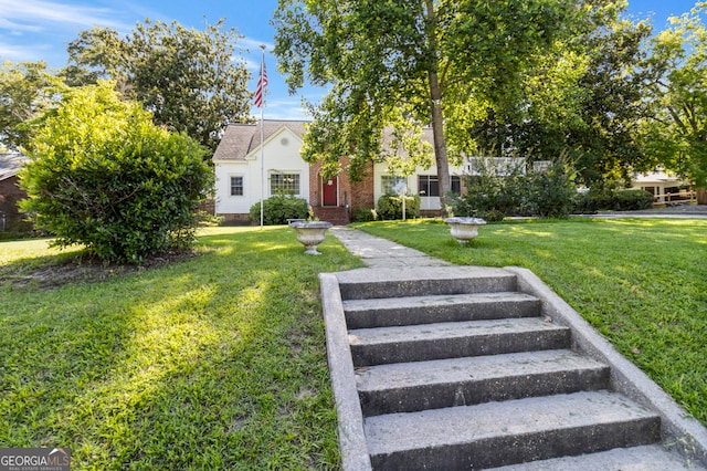 view of property hidden behind natural elements with a front yard