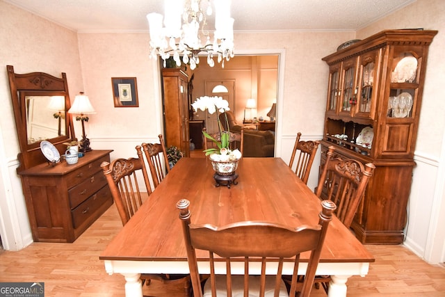 dining area featuring light wood-type flooring, a chandelier, and ornamental molding