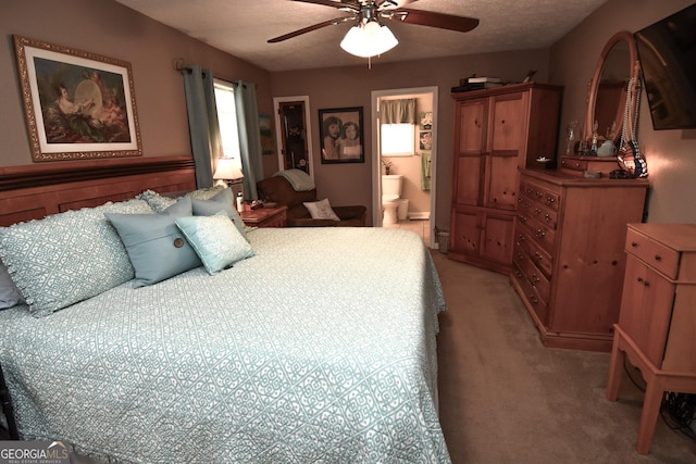 bedroom with a ceiling fan, light carpet, a textured ceiling, and ensuite bathroom