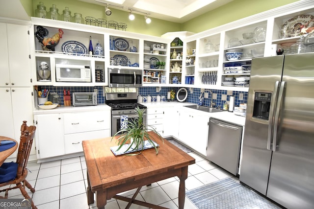 kitchen featuring light tile patterned flooring, a sink, stainless steel appliances, and open shelves