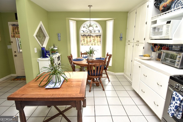 dining space featuring a toaster, light tile patterned floors, and baseboards