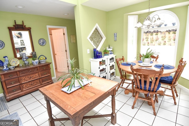 dining room with light tile patterned floors, baseboards, and a chandelier