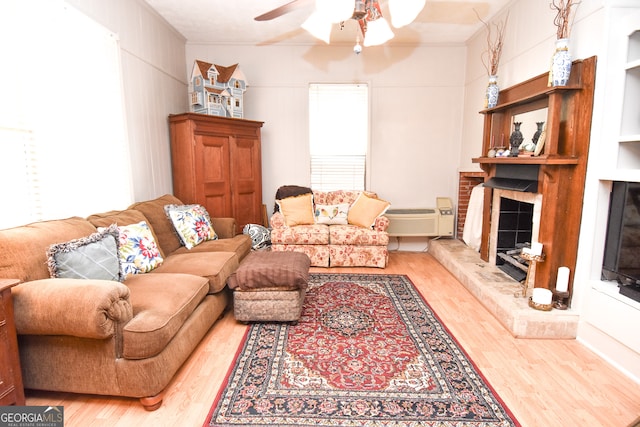 living room with hardwood / wood-style flooring, built in features, and ceiling fan