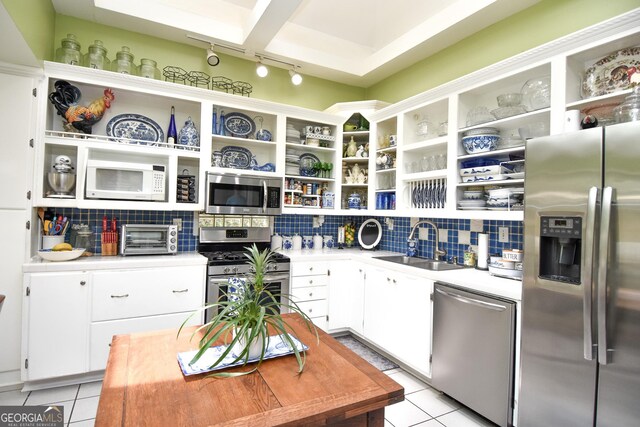 kitchen featuring open shelves, stainless steel appliances, and a sink