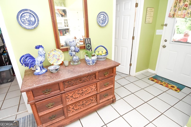 foyer with light tile patterned floors and baseboards