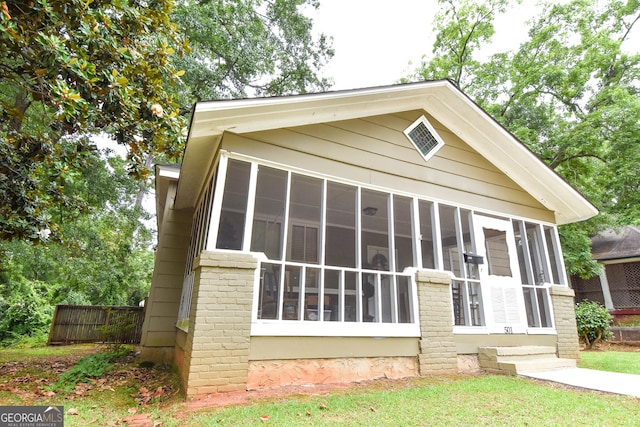 view of front facade with fence and a sunroom