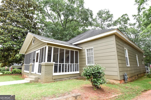 view of home's exterior with a yard and a sunroom