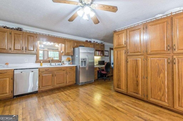 kitchen with sink, light hardwood / wood-style flooring, stainless steel appliances, and a textured ceiling