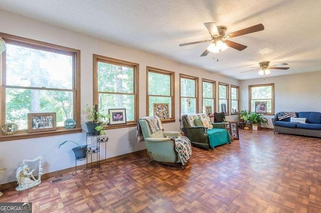 sunroom / solarium featuring ceiling fan