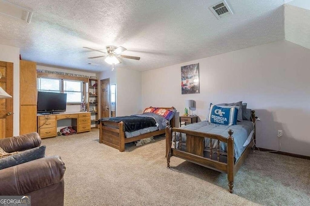 bedroom with ceiling fan, carpet, and a textured ceiling