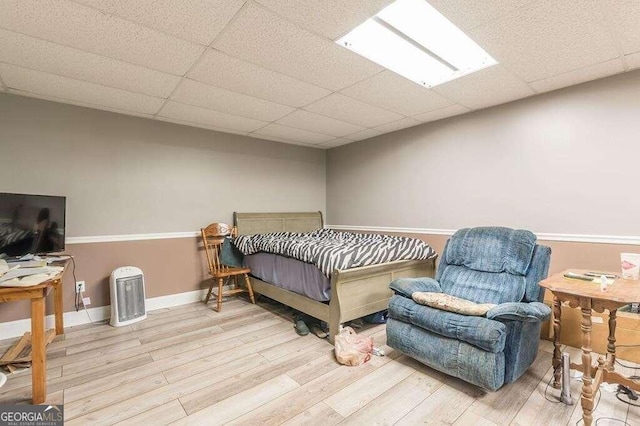 bedroom featuring a drop ceiling and light wood-type flooring