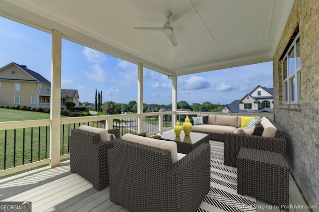 wooden terrace with ceiling fan, a lawn, and outdoor lounge area