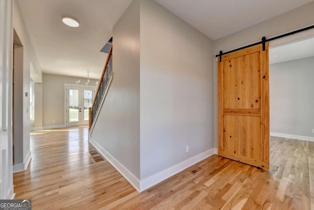 hallway with a chandelier and light wood-type flooring