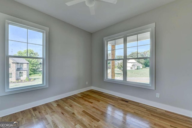 empty room featuring ceiling fan, light hardwood / wood-style floors, and a healthy amount of sunlight