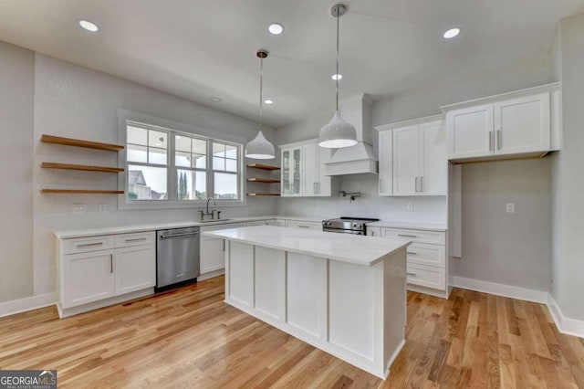 kitchen featuring a kitchen island, white cabinetry, appliances with stainless steel finishes, and light hardwood / wood-style floors