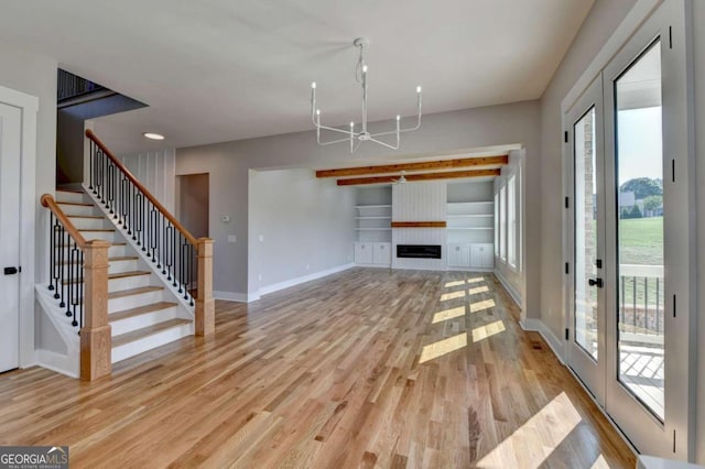 unfurnished living room featuring french doors, light hardwood / wood-style floors, and a chandelier