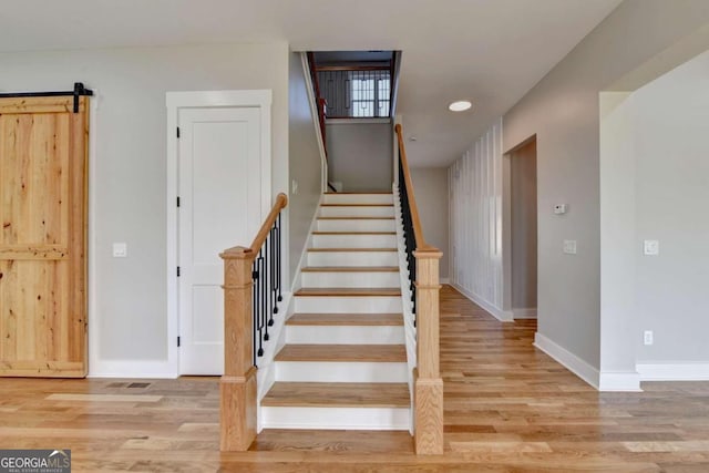 stairs featuring hardwood / wood-style flooring and a barn door