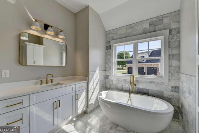 bathroom with vanity, a tub to relax in, and tile walls