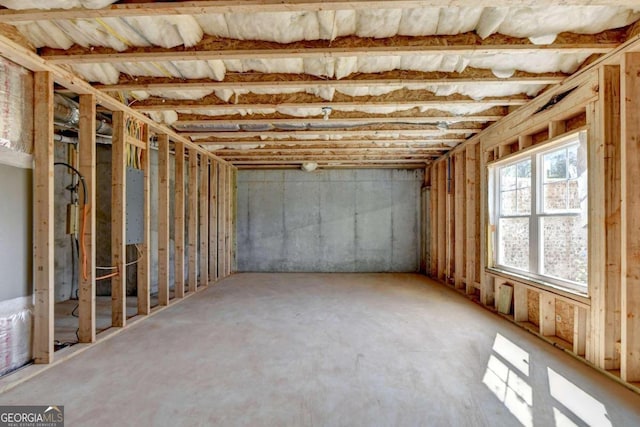 miscellaneous room featuring electric panel and concrete flooring