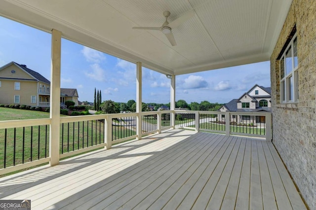 wooden deck with a yard and ceiling fan